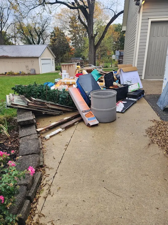 Dumpster being loaded with debris for 12 Yard Dumpster Rental in Flat Rock